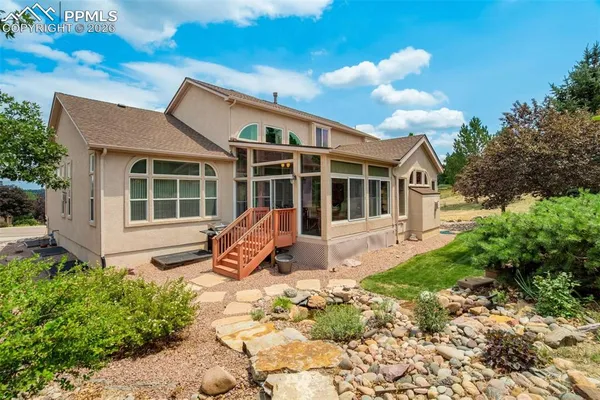 a view of a house with backyard and sitting area