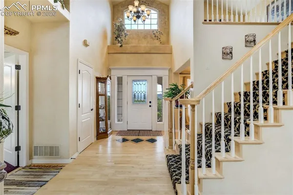 a view of an entryway with wooden floor and stairs