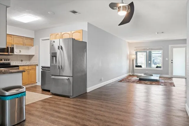 a kitchen with stainless steel appliances granite countertop a refrigerator a stove and a wooden floors
