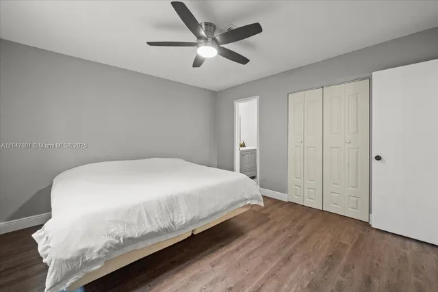 a spacious bedroom with a bed and a ceiling fan