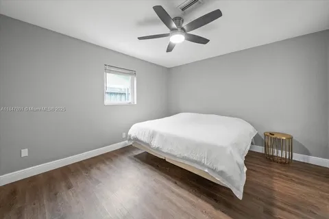 a bed sitting in a spacious bedroom next to a window