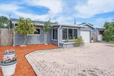 a front view of a house with a yard and potted plants