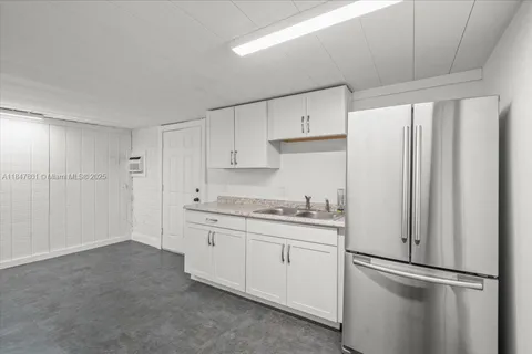 a kitchen with stainless steel appliances granite countertop a refrigerator sink and white cabinets
