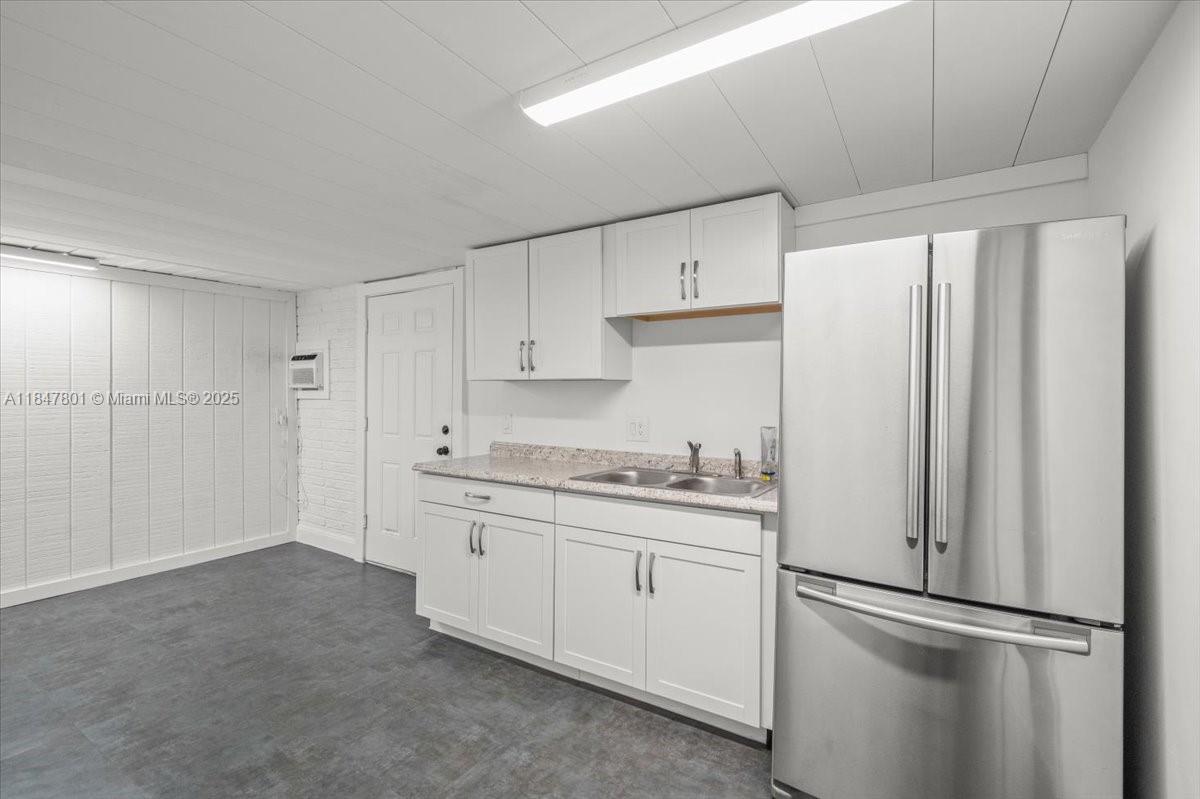 3751 Northeast 16th Avenue Pompano Beach, FL 33064 - Photo 31 of 41 a kitchen with stainless steel appliances granite countertop a refrigerator sink and white cabinets