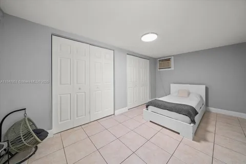 a spacious bedroom with a bed and a mirror