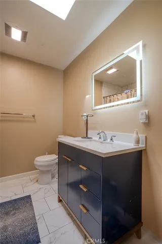 a bathroom with a sink a toilet and mirror