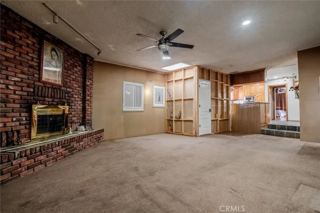 a view of an empty room with ceiling fan