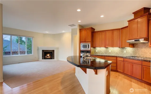 a kitchen with granite countertop a sink stove and cabinets