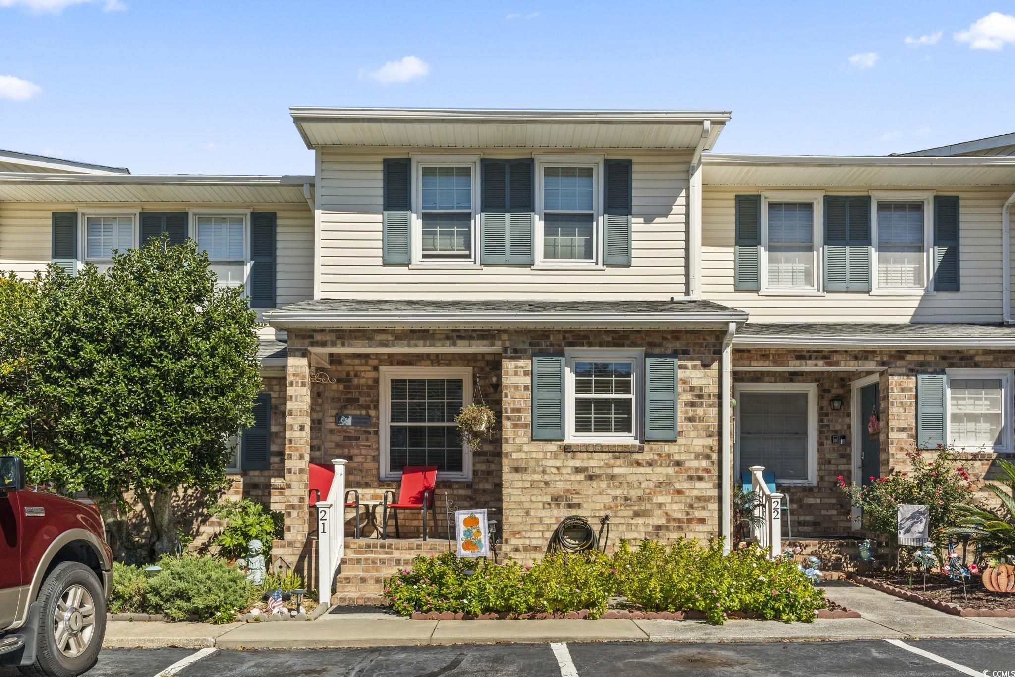 View of exterior entry featuring a porch, brick siding, and roof with shingles