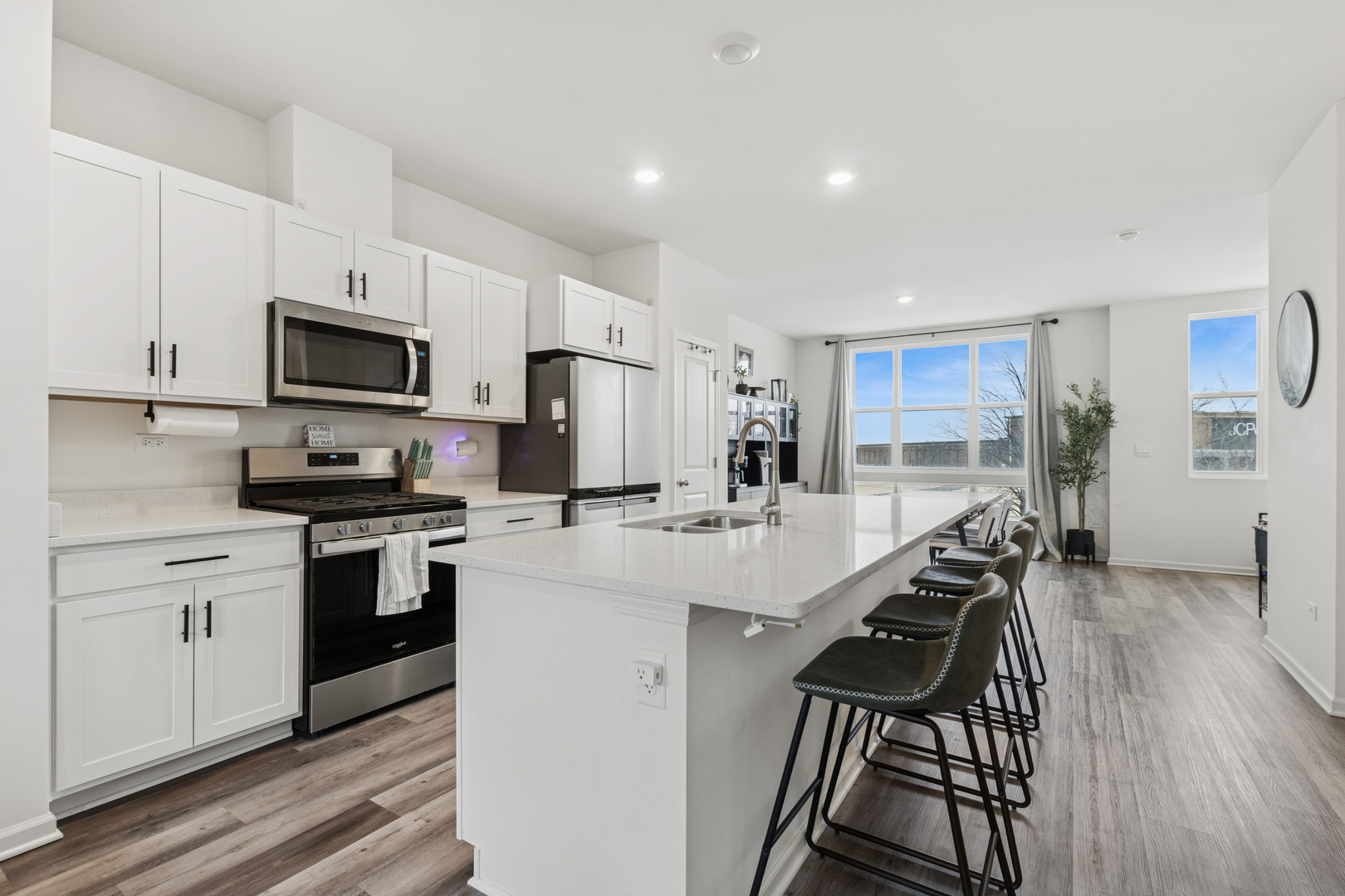 306 Summit Circle Lombard, IL 60148 - Photo 7 of 23 a kitchen with stainless steel appliances kitchen island granite countertop a stove top oven a sink a dining table and chairs with wooden floor