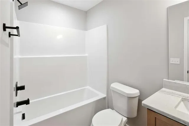 a white toilet and tub sitting next to a bathroom sink