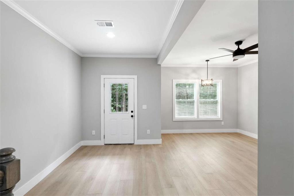 159 Brad Street Royston, GA 30662 - Photo 2 of 21 an empty room with wooden floor and windows