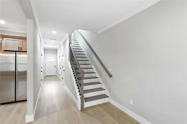 a view of a hallway with staircase and white walls