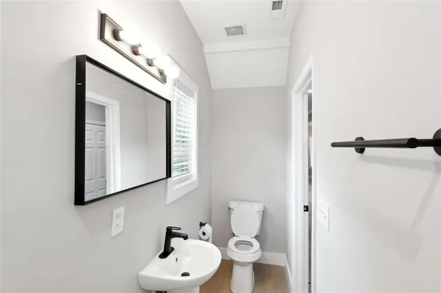 a bathroom with a toilet sink and mirror