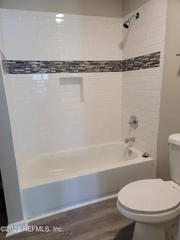 a bathroom with a toilet and a bathtub