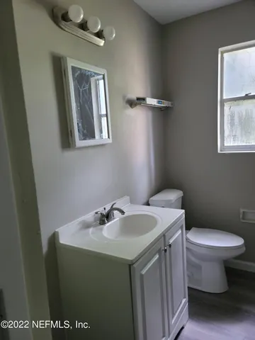 a bathroom with a sink toilet and mirror