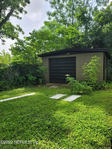 a view of a backyard with potted plants and large tree