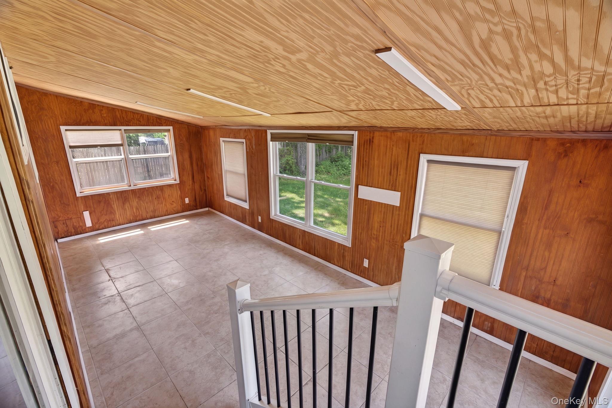 7 Walnut Street Poughkeepsie, NY 12601 - Photo 17 of 30 Step into the expansive enclosed patio, a bright and inviting retreat designed for year-round enjoyment. Surrounded by walls of windows, this sun-filled space is bathed in natural light, creating a warm and airy atmosphere while offering beautiful views of the surrounding yard.