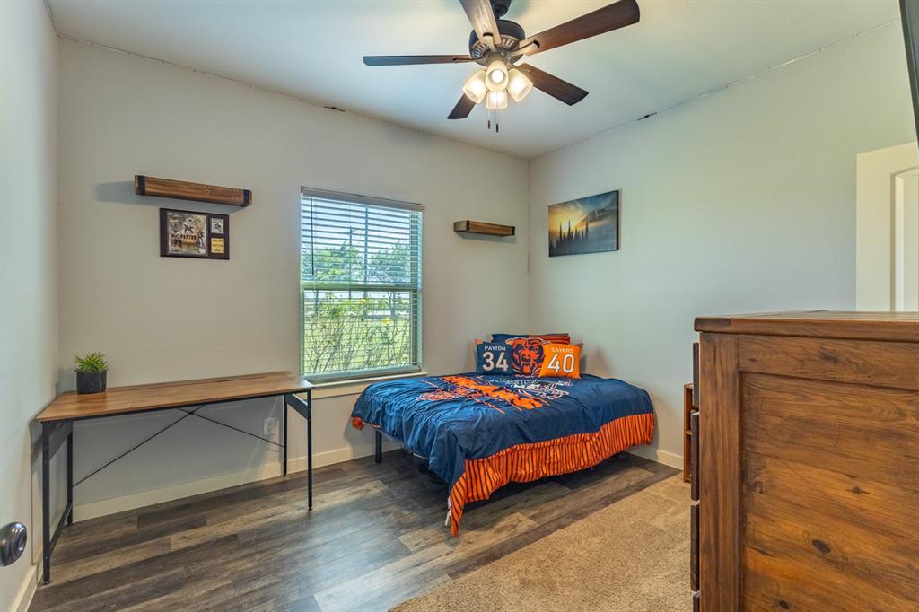 14910 Old Stoney Road Ponder, TX 76259 - Photo 25 of 36 a bedroom with a bed and a chandelier