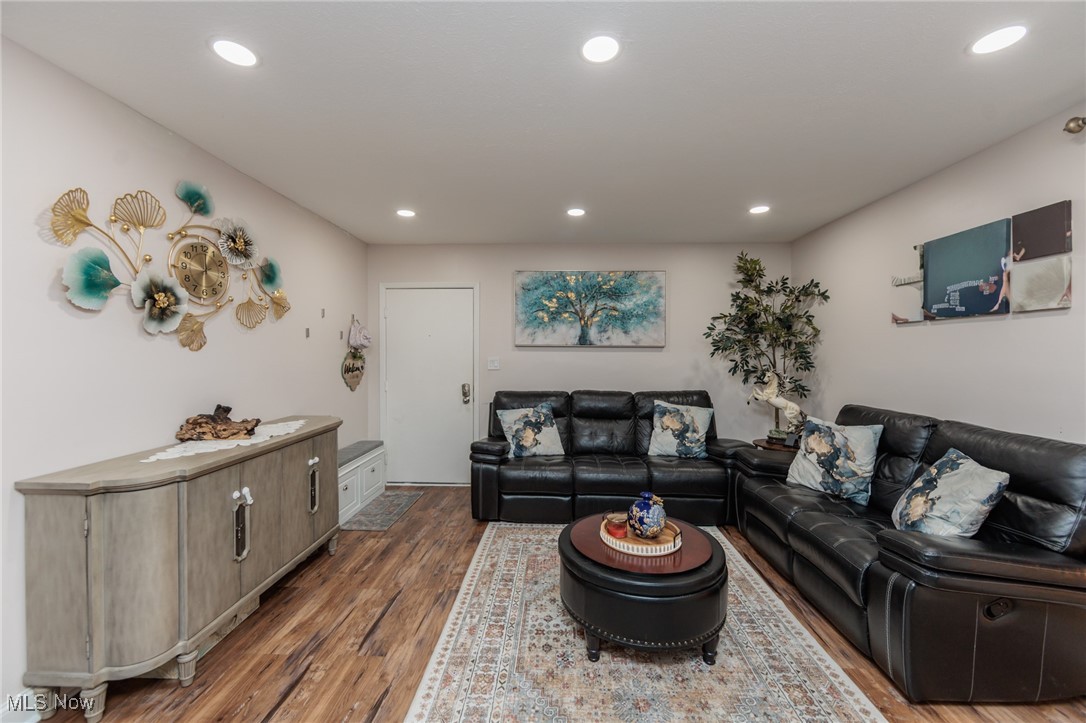 Living area with wood finished floors and recessed lighting