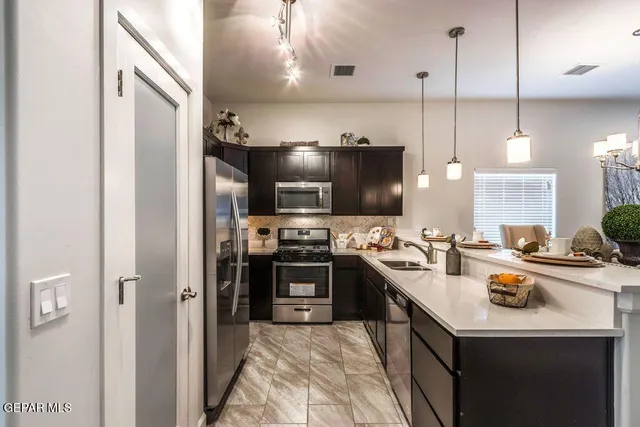 a kitchen with kitchen island a sink stove and refrigerator