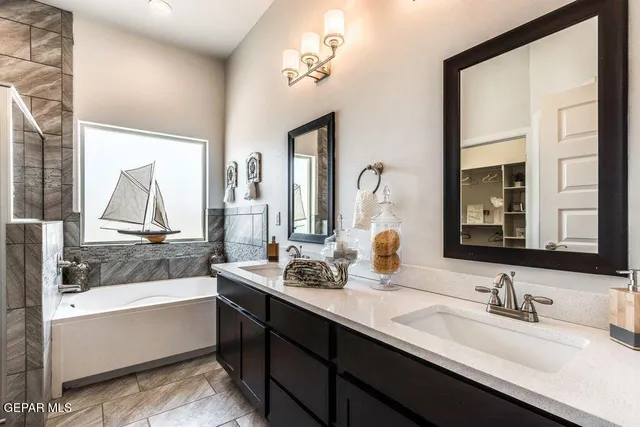 a bathroom with double vanity sinks and a bathtub