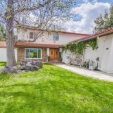 a view of house with backyard and a sitting area
