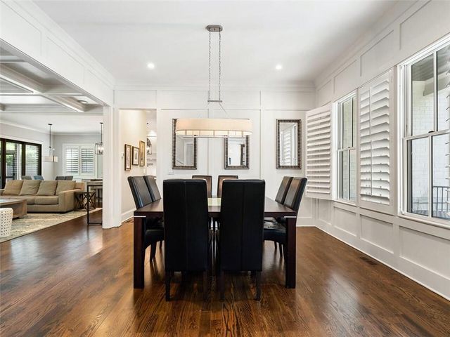 a living room with dining table and a wooden floor