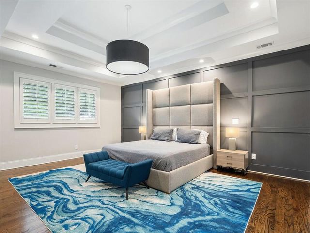 a spacious bedroom with a bed and a chandelier