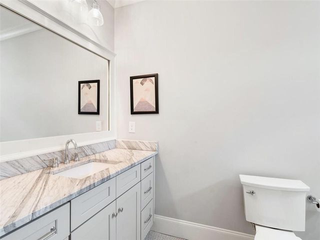 a bathroom with a granite countertop toilet sink and shower