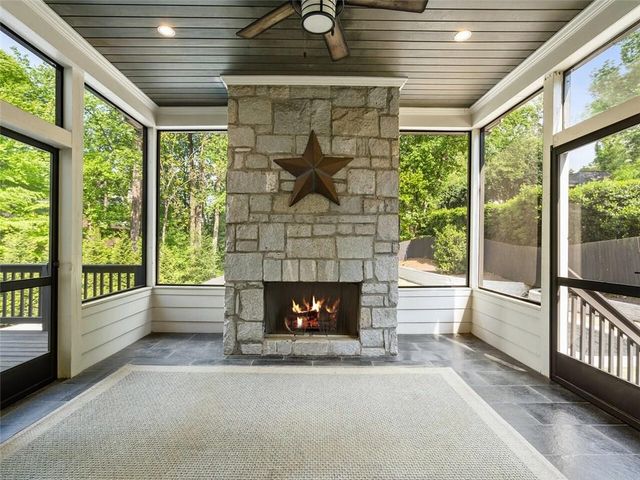 a living room with a fireplace and a floor to ceiling window