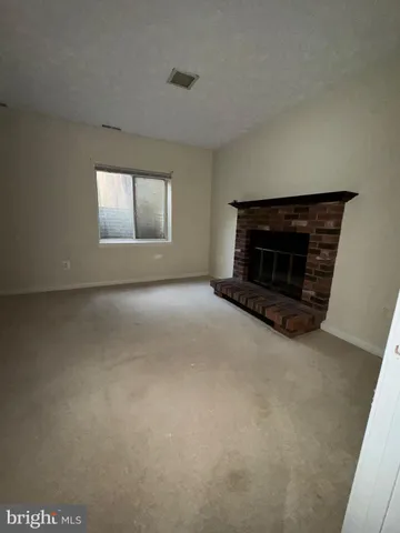 a view of empty room with a fireplace