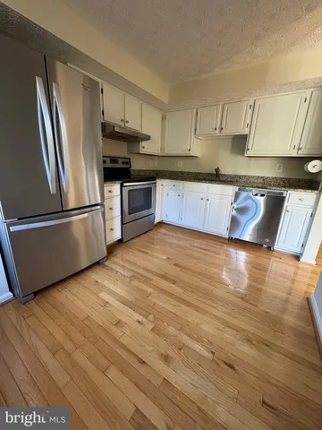 a kitchen with granite countertop stainless steel appliances and wooden cabinets