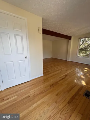 a view of an empty room with wooden floor