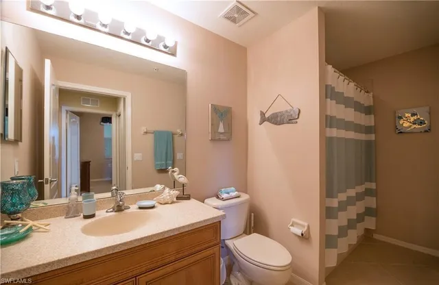 a bathroom with a sink vanity mirror and toilet