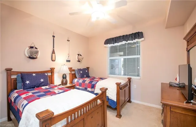 a bedroom with a bed and a flat tv screen on the dresser