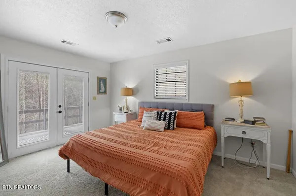 a bedroom with a bed and a flat tv screen on dresser