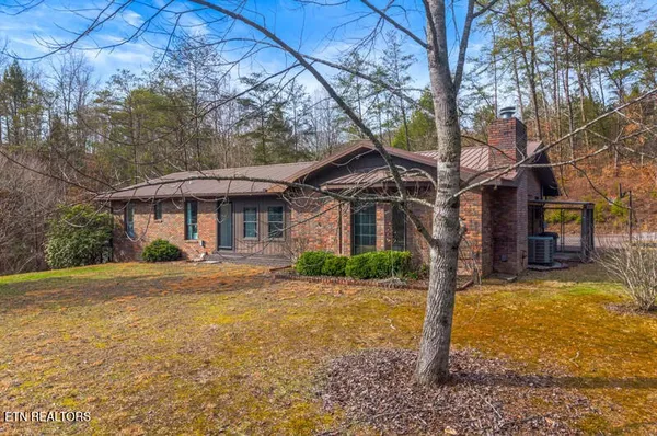 a view of a house with a yard and tree