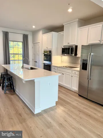 a large kitchen with cabinets and wooden floor