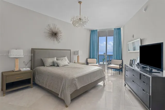 a bedroom with a bed and a flat tv screen on a dresser