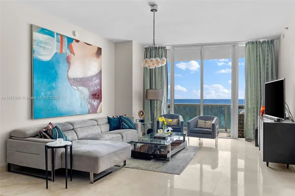 a living room with furniture a flat screen tv and a large window