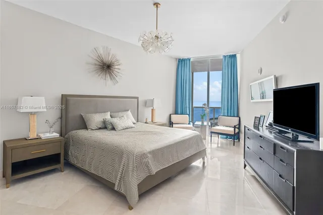 a bedroom with a bed and a flat tv screen on a dresser