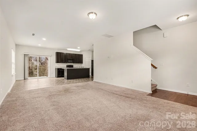 an empty room with a fireplace and windows