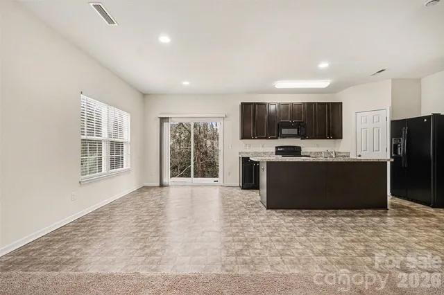 a kitchen with kitchen island a refrigerator sink stove and microwave