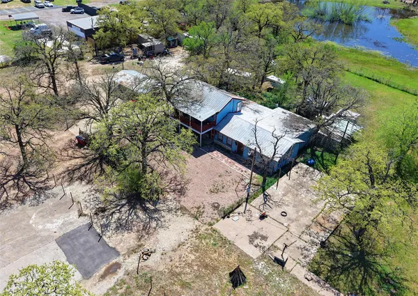 an aerial view of a house with a yard and lake view