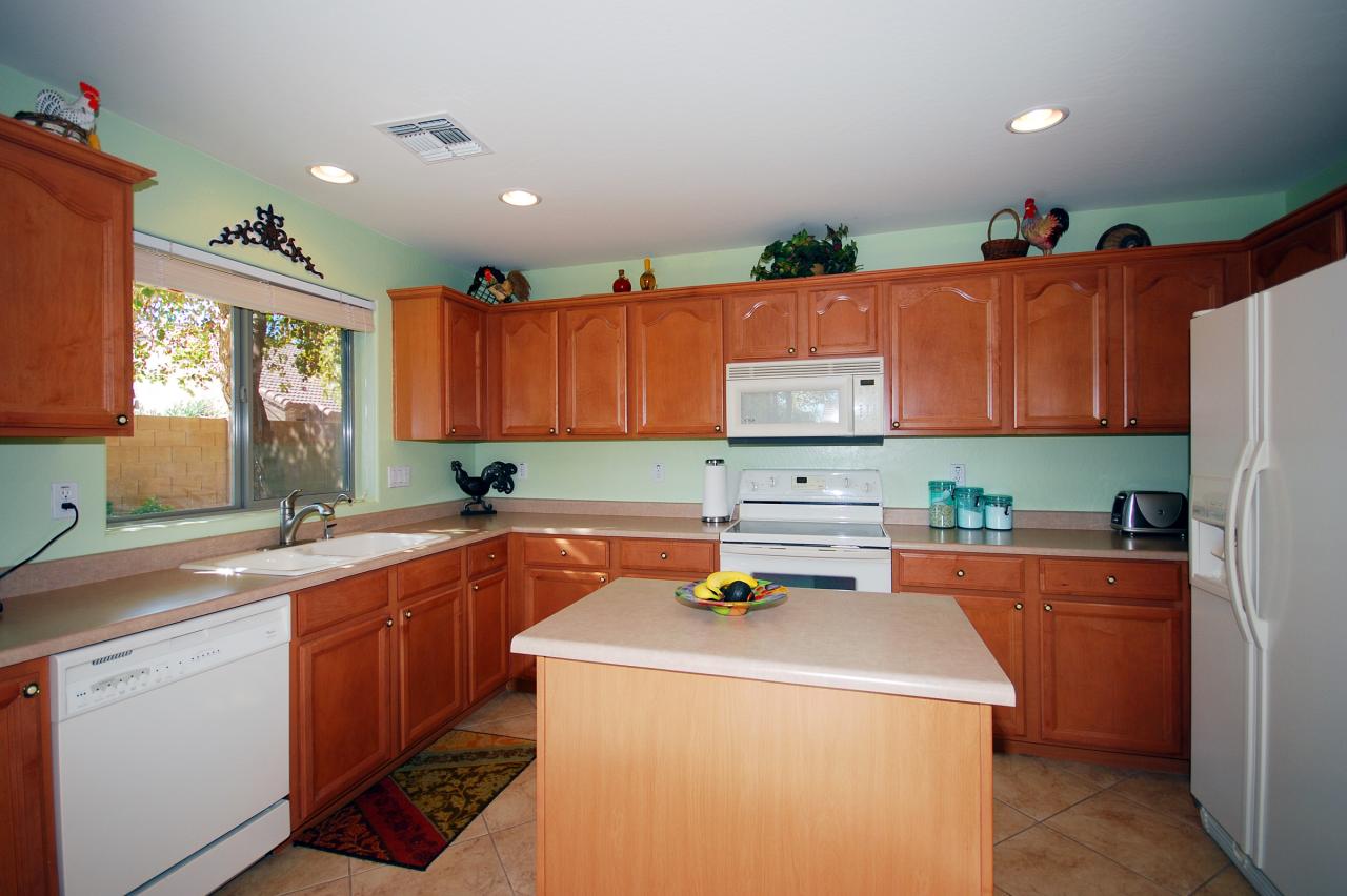 2043 West Tanner Ranch Road Queen Creek, AZ 85144 - Photo 3 of 18 a kitchen with a sink a stove cabinets and a window
