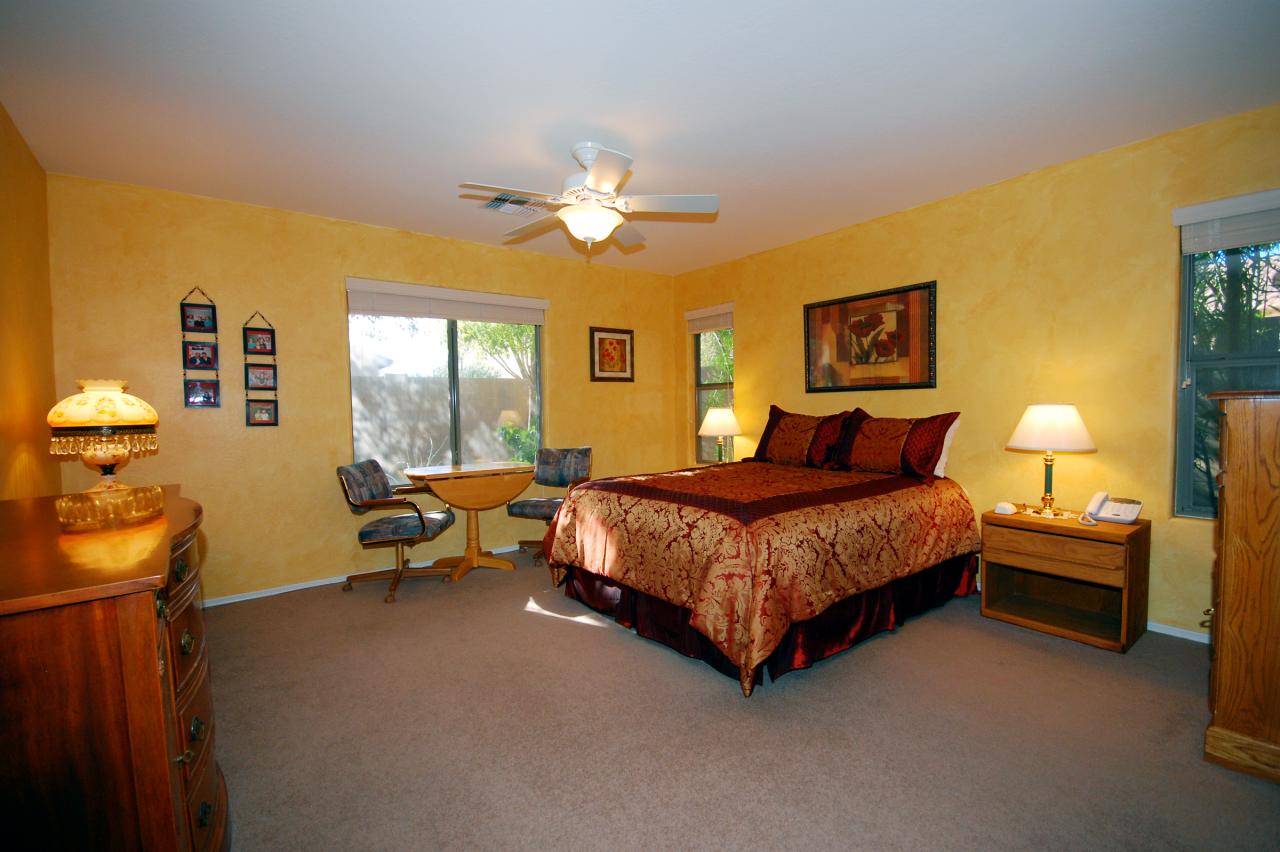 2043 West Tanner Ranch Road Queen Creek, AZ 85144 - Photo 4 of 18 a spacious bedroom with a bed and a chandelier