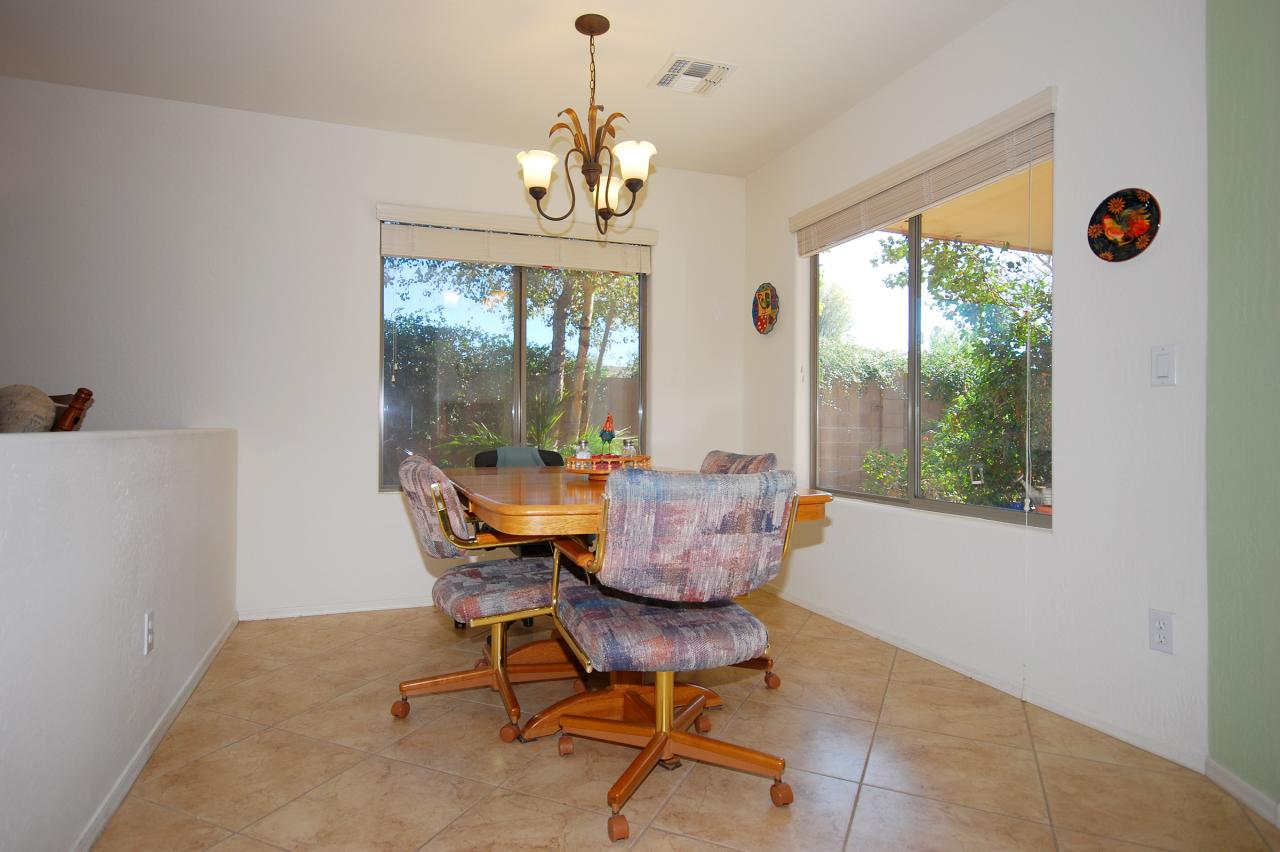 2043 West Tanner Ranch Road Queen Creek, AZ 85144 - Photo 10 of 18 a view of a dining room with furniture wooden floor and chandelier