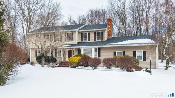 a front view of a house with a yard covered in snow