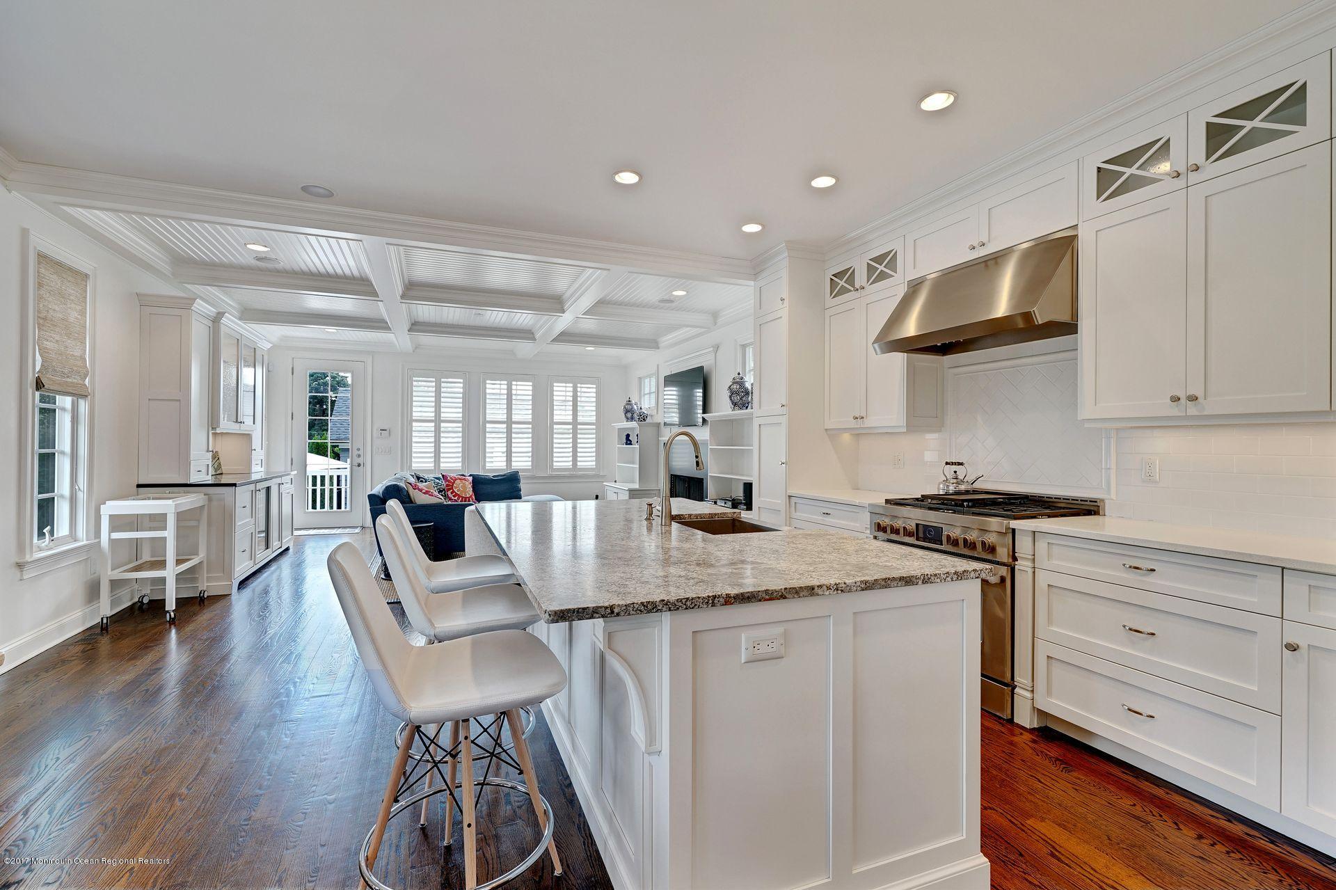 401 Monmouth Avenue Spring Lake, NJ 07762 - Photo 11 of 24 a kitchen with stainless steel appliances granite countertop a stove top oven a dining table and chairs with wooden floor